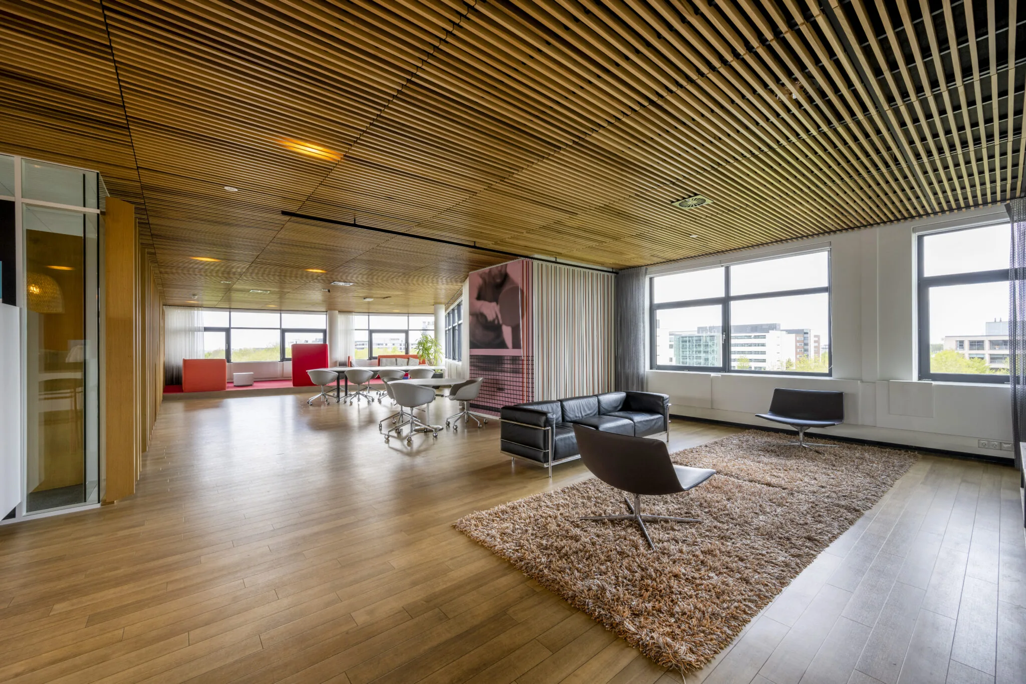 Modern ingerichte kantoorruimte aan de Boeing Avenue met houten plafond, designmeubilair en grote ramen met uitzicht op de stad.