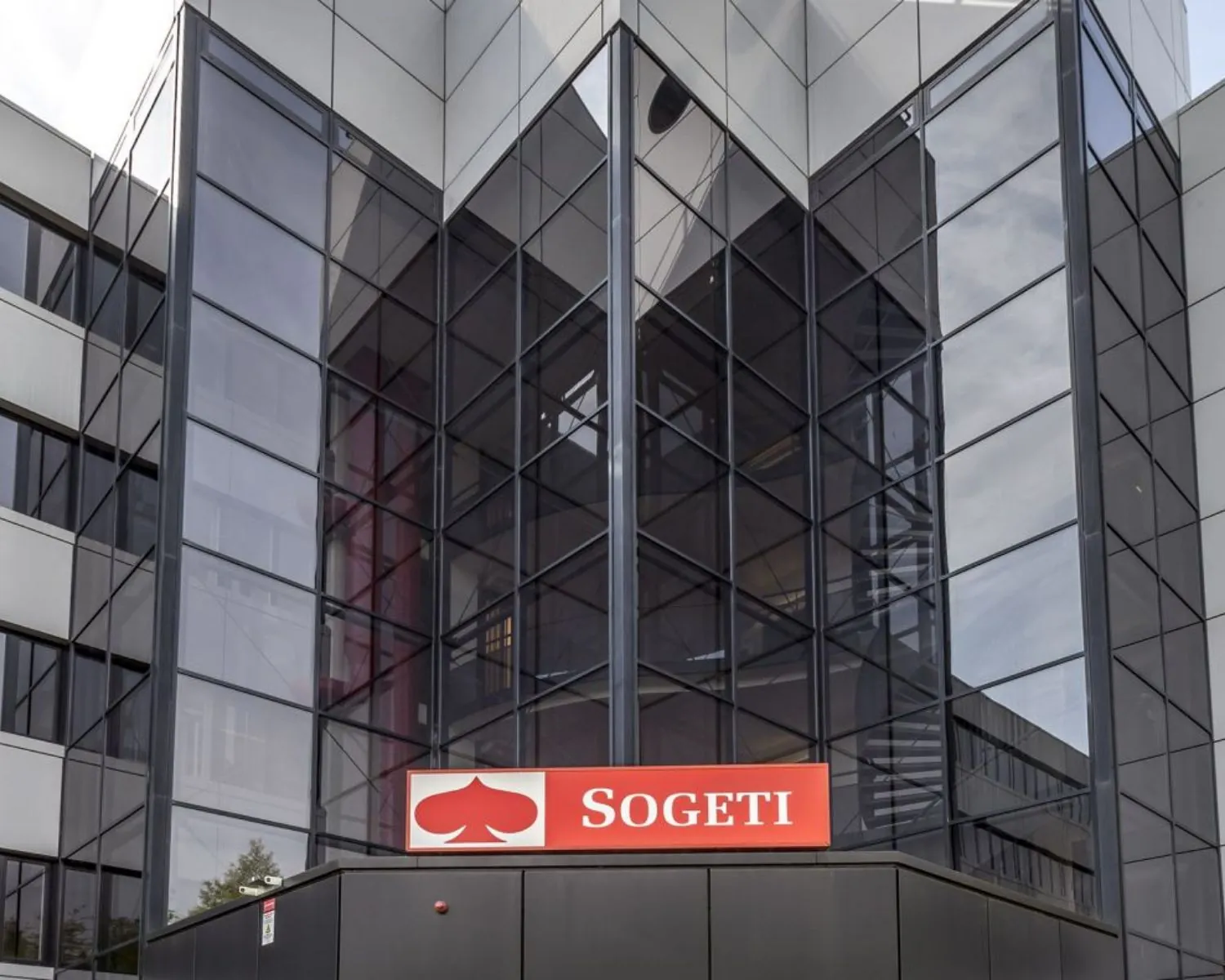 Glazen gevel van een modern kantoorgebouw met het rode Sogeti-logo boven de ingang.