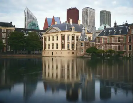 Historic government buildings and modern skyscrapers reflected in the Hofvijver in The Hague.