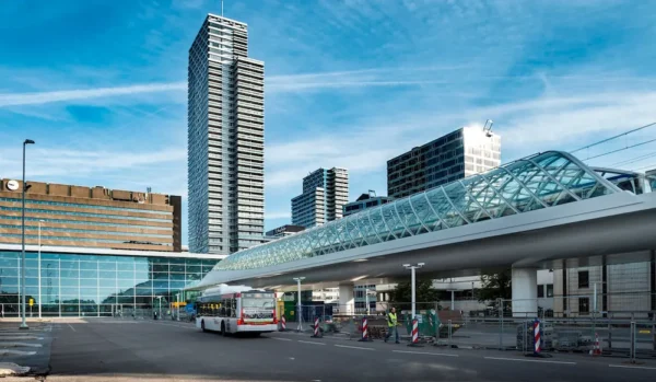View of Den Haag Central Station with modern architecture and a glass-covered tram viaduct.