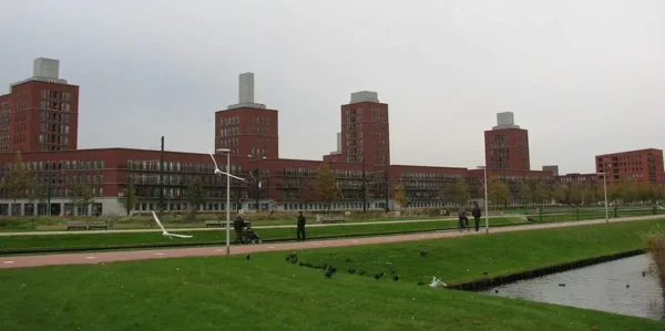 Modern residential buildings in Den Haag Leidschenveen-Ypenburg with a park and canal in the foreground.