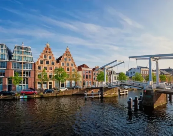 Historic canal houses and a white drawbridge over the water in Haarlem, Netherlands.