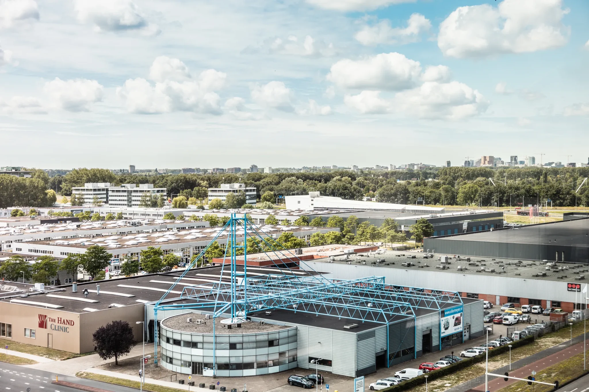 Luchtfoto van een bedrijventerrein aan de Herengracht 204 met diverse bedrijfspanden en kantoren, waaronder The Hand Clinic.