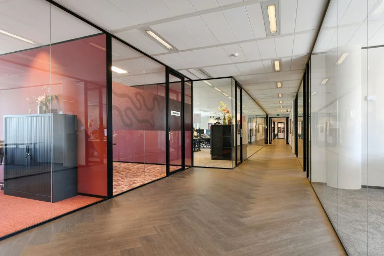 Gang van een modern kantoor met glazen wanden langs de Jachthavenweg.