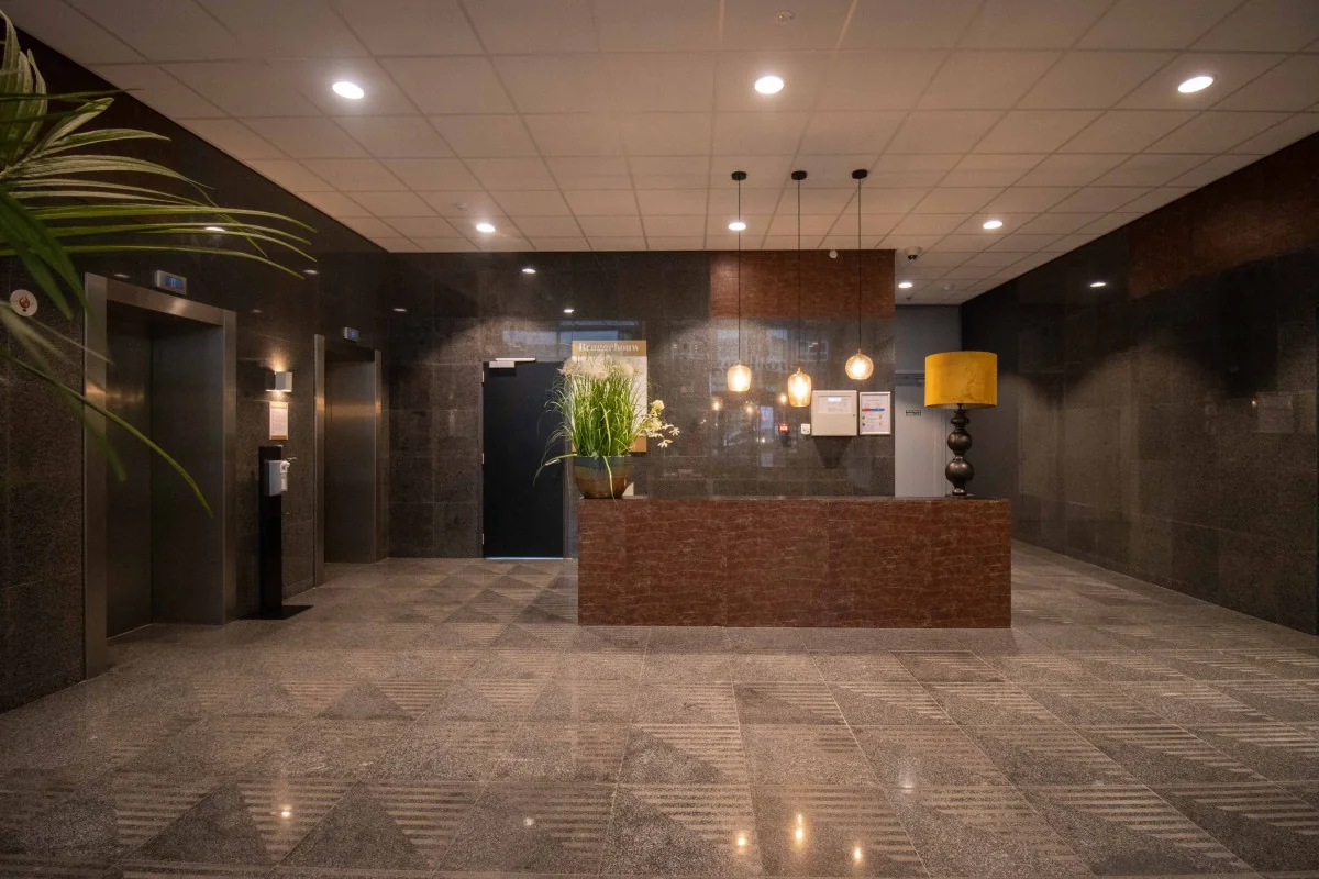 Moderne kantoorhal met receptie en liften aan het Bos en Lommerplein 11 in Amsterdam.
