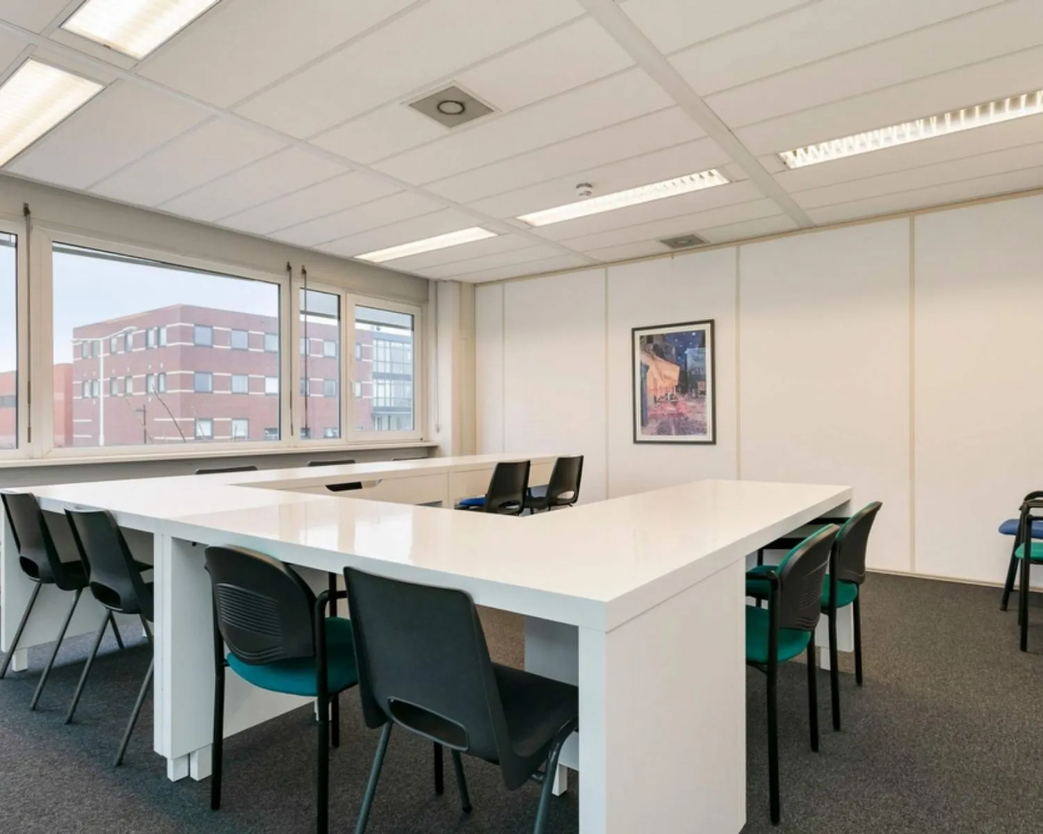Moderne kantoorruimte aan de Curieweg 7 in Spijkenisse met grote witte vergadertafels, meerdere stoelen en veel daglicht.