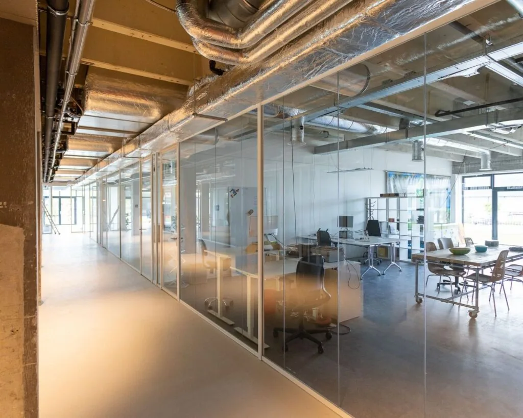 Moderne kantoorruimte aan de Hofmanweg in Haarlem met glazen wanden en industriële afwerking.