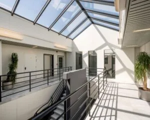 Lichte en moderne kantoorruimte met dakramen en een centrale trap aan de Overschiestraat 180 in Amsterdam.