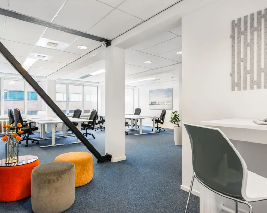 Moderne, lichte kantoorruimte met werkplekken en kleurrijke zitpoefs aan de Posthoornstraat 17 in Rotterdam.