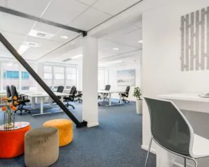 Moderne, lichte kantoorruimte met werkplekken en kleurrijke zitpoefs aan de Posthoornstraat 17 in Rotterdam.
