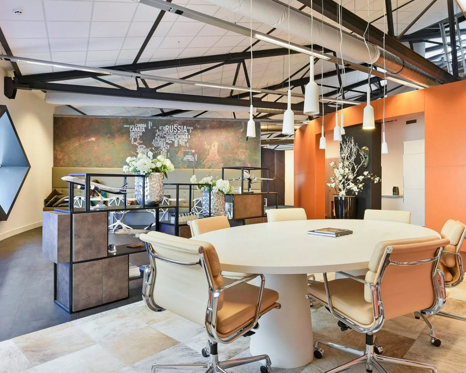 Moderne kantoorruimte in SugarCity met ronde vergadertafel, designstoelen en industriële details.