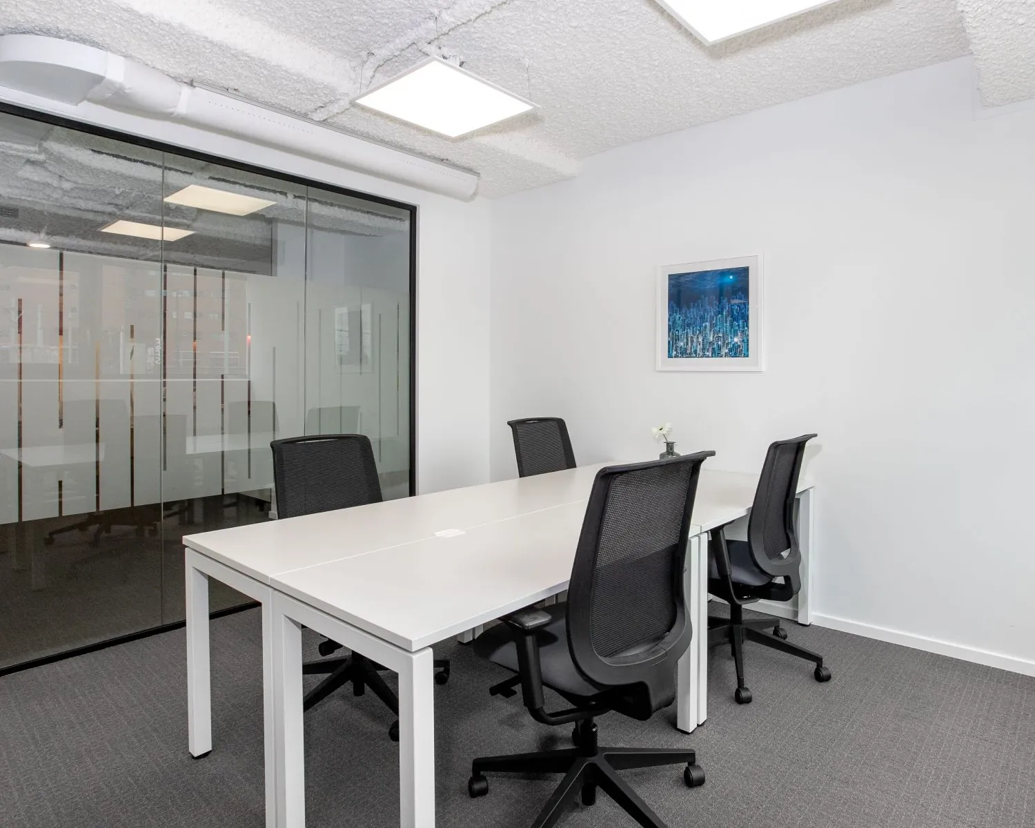 Moderne kantoorruimte met vier bureaustoelen en glazen wand aan het Stationsplein 13A in Amersfoort.