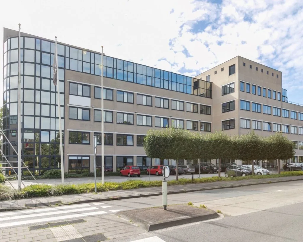 Modern kantoorgebouw aan de Paterswoldseweg 806-8 met grote ramen en parkeergelegenheid voor de deur.