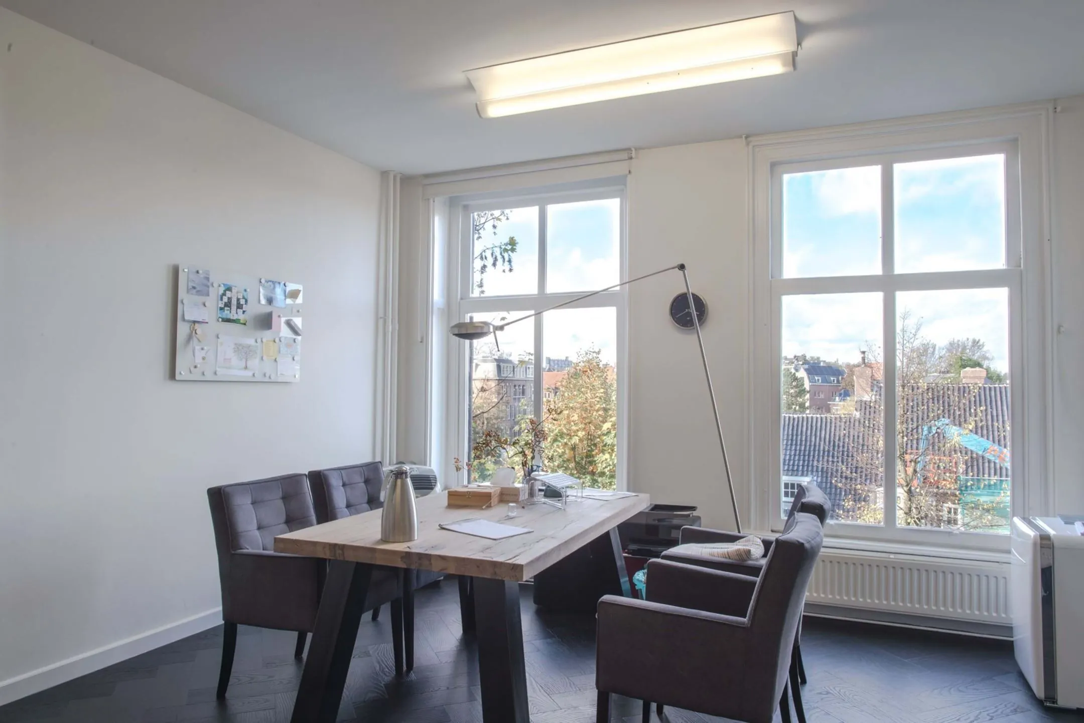 Lichte kantoorruimte aan de Sophialaan 21 in Amsterdam met grote ramen, houten vergadertafel en moderne inrichting.