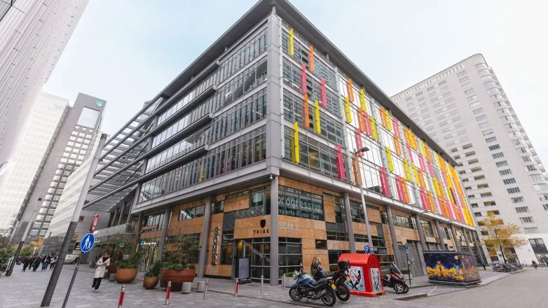 Een modern kantoorgebouw aan de Claude Debussylaan 15 met kleurrijke verticale panelen op de gevel.