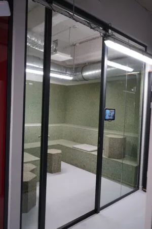 Moderne vergaderruimte met glazen wanden en zitbanken van terrazzo in kantoor aan Weesperplein 4A in Amsterdam.