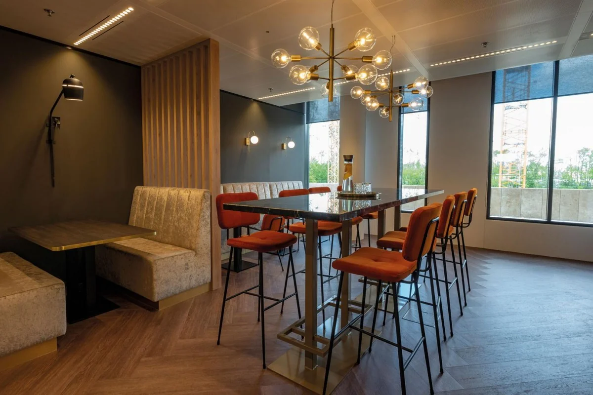 Moderne kantoorruimte met hoge tafels en oranje stoelen op de Gustav Mahlerlaan in Amsterdam.