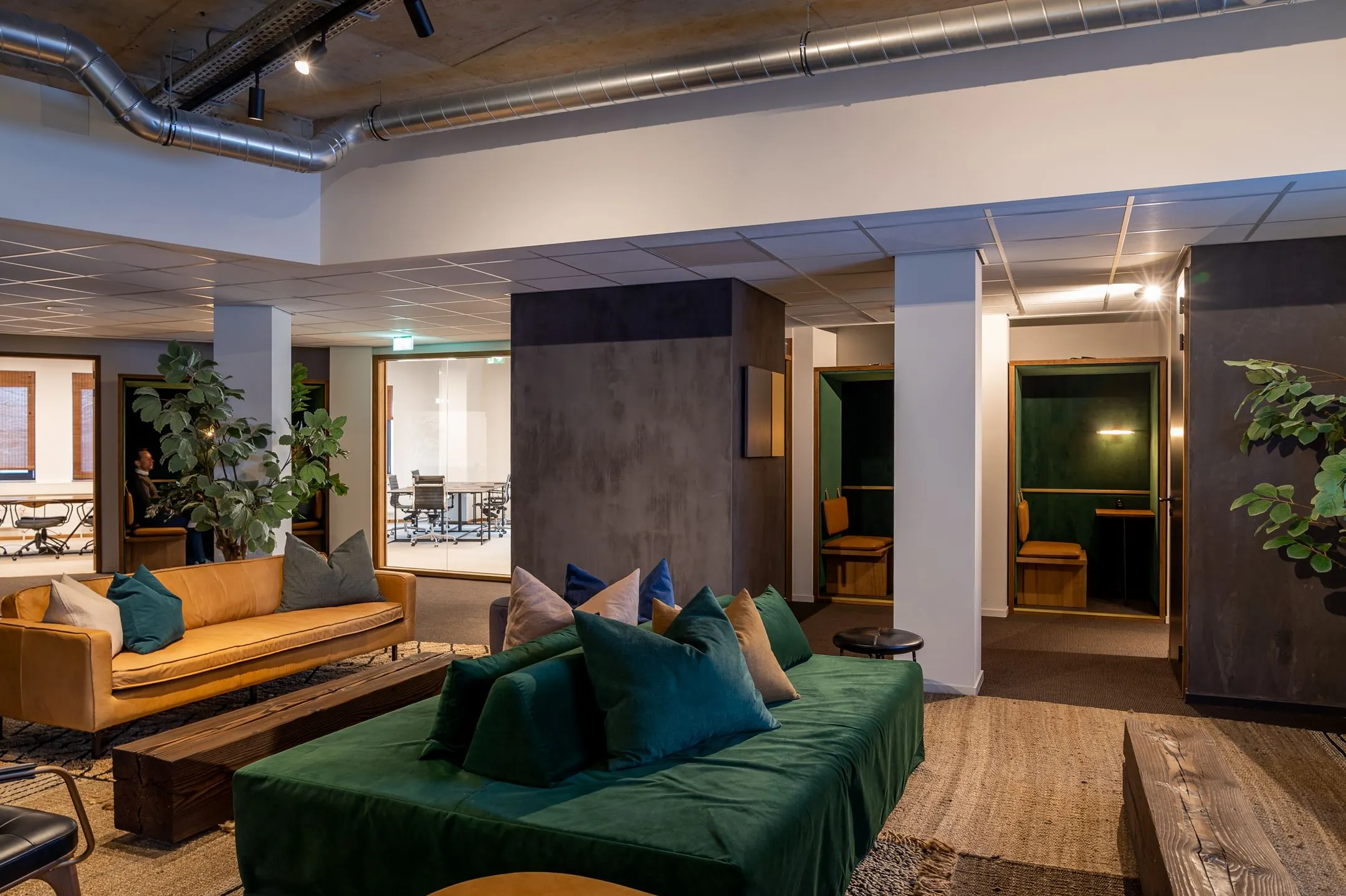 Modern ingerichte lounge- en werkruimte in kantoor Emmasingel 33 met comfortabele zitbanken en afgesloten werkplekken.