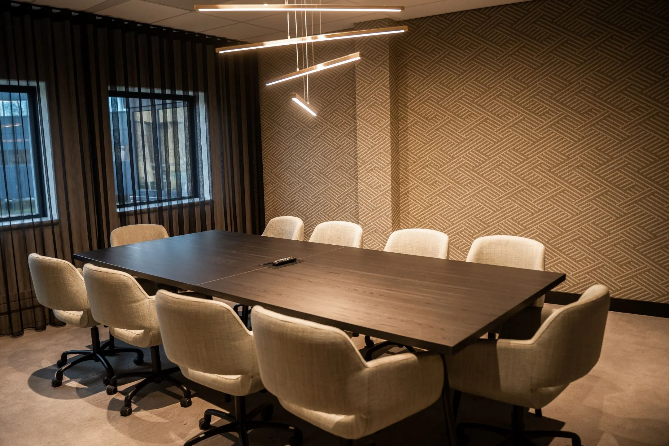 Moderne vergaderruimte in kantoor aan de Reitscheweg met lange tafel, comfortabele stoelen en sfeervolle verlichting.