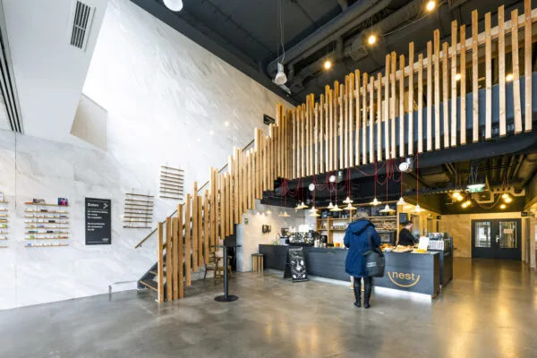 Moderne lobby van Kronenburg met houten trap, koffiebar 'Nest' en industriële inrichting.