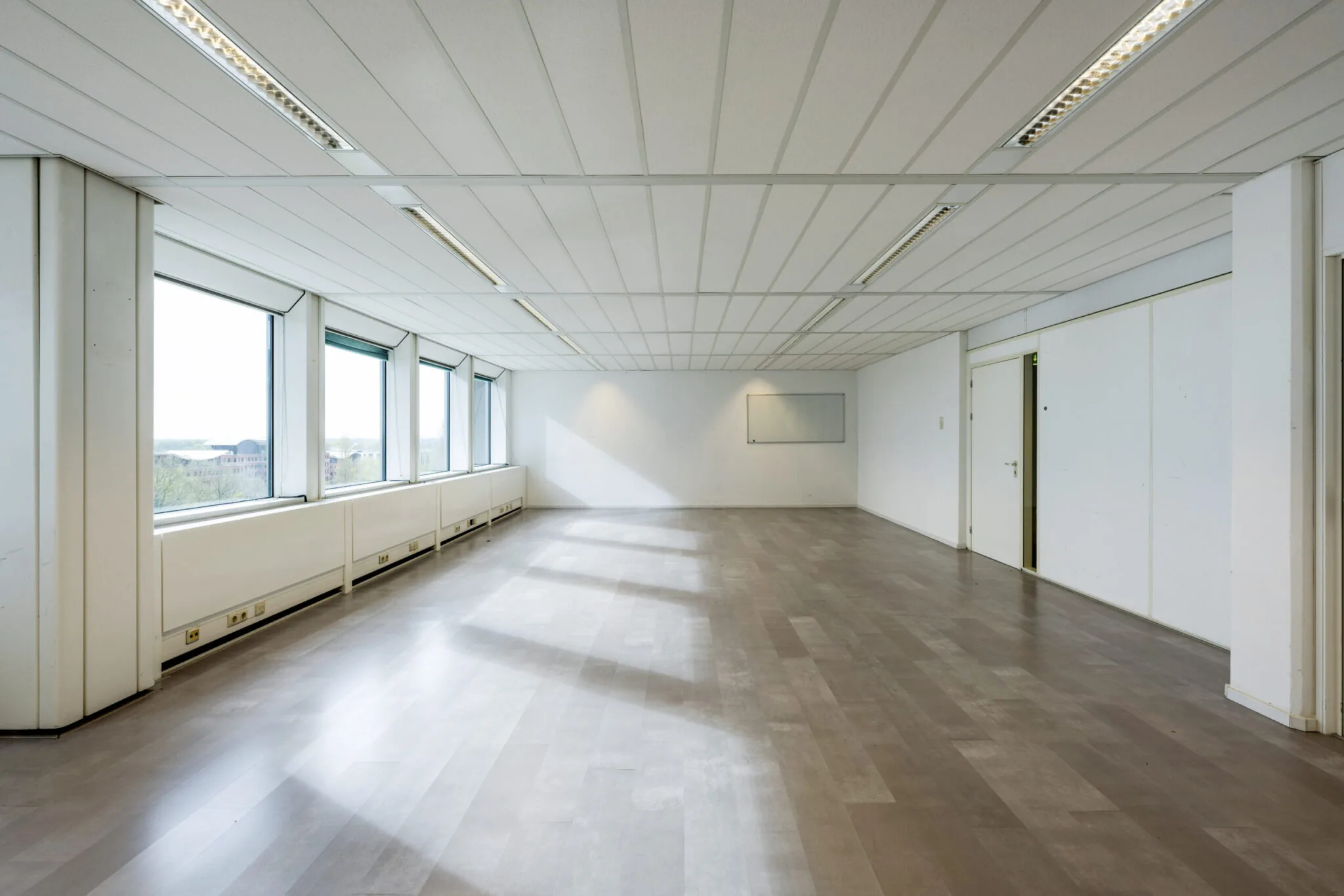 Lichte, lege kantoorruimte in Kronenburg 038 met grote ramen en systeemplafond.