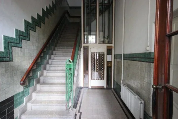 Hal met een trap en een lift in een historisch gebouw aan de Prinsengracht 39.