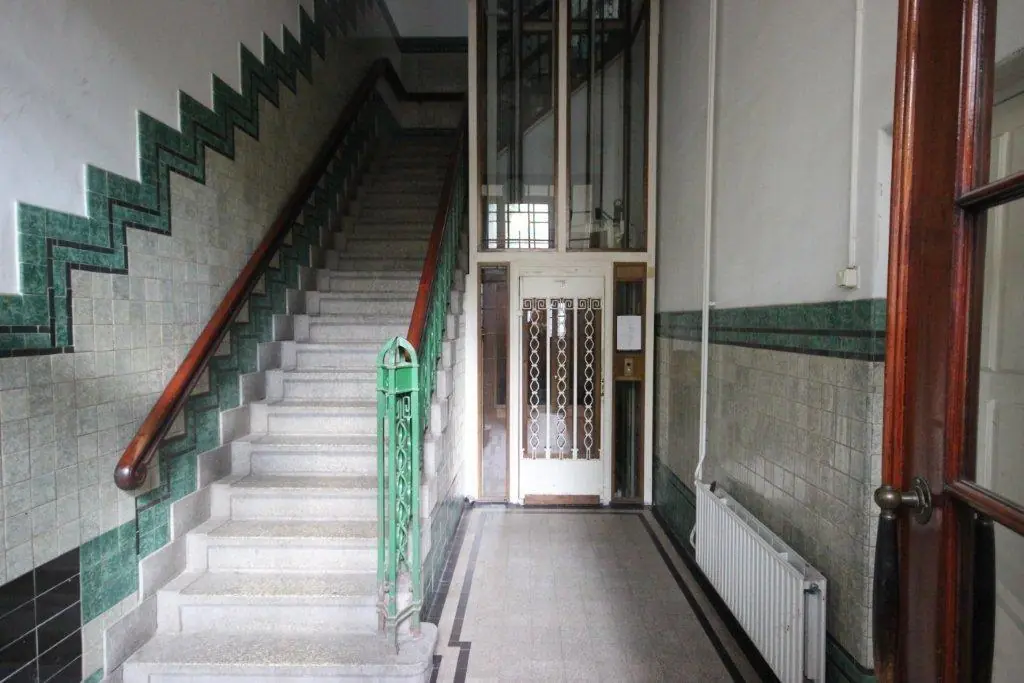 Hal met een trap en een lift in een historisch gebouw aan de Prinsengracht 39.