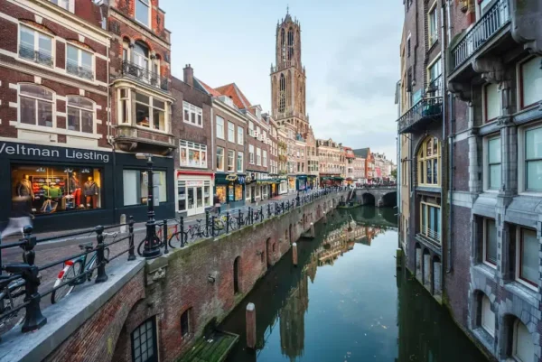 Historic canal view in Utrecht city center with the Dom Tower in the background.