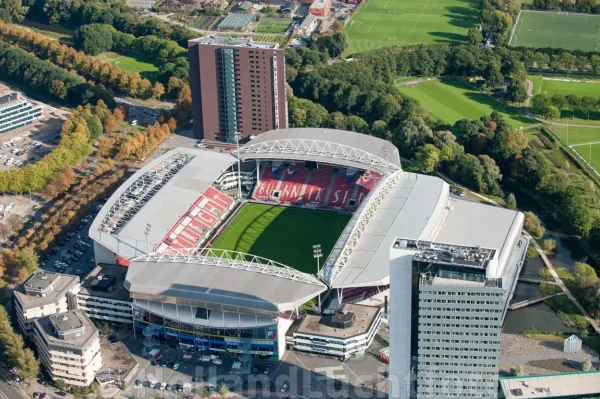 Aerial view of Stadion Galgenwaard in Utrecht, surrounded by office buildings, trees, and sports fields.
