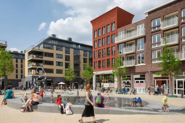 Children play in a water fountain surrounded by modern apartment buildings in Utrecht Leidsche Rijn.