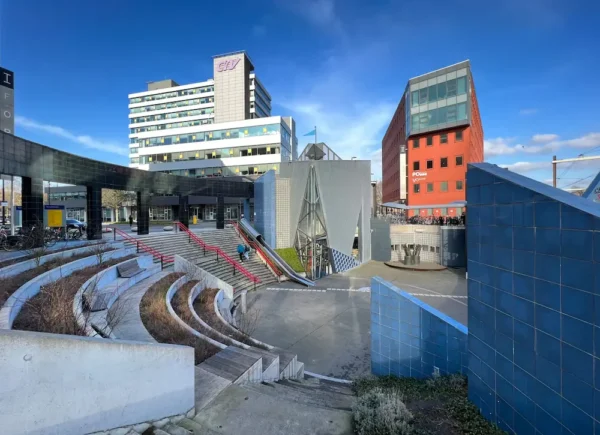 Modern urban architecture at Utrecht Overvecht station with a stepped amphitheater and surrounding office buildings.
