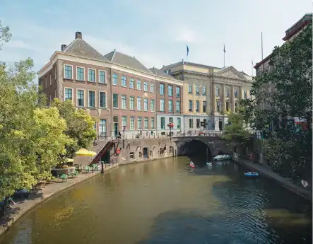 A canal in Utrecht with historic buildings and small boats on the water.